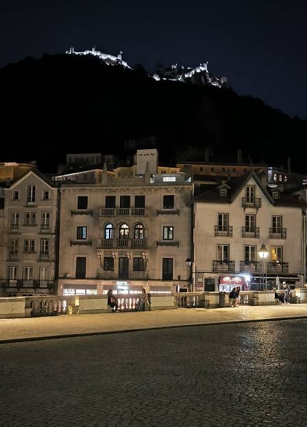 Es el centro historico de Sintra de noche. De fondo el castillo de los moros iluminado